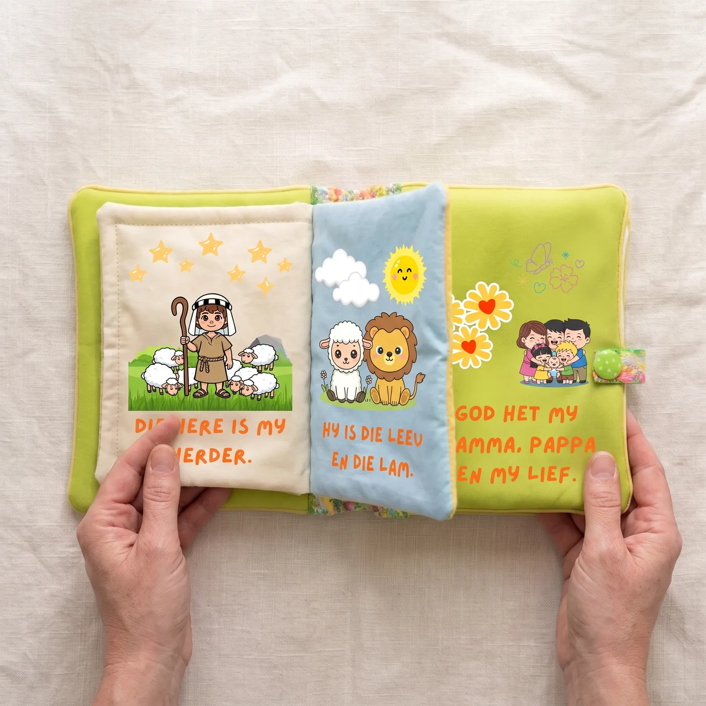 The Baby Bible held open, its soft fabric pages fanned out