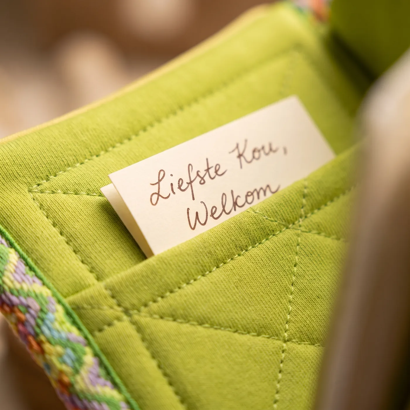 A handwritten dedication note being tucked into the inner fabric pocket of the Baby Bible